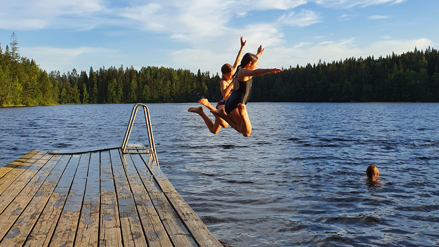 Lapset hyppäävät laiturilta veteen.