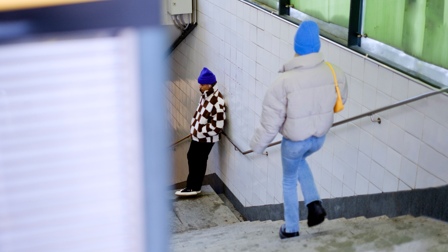 Nuori kävelee aseman portaita, alempana toinen nuori.