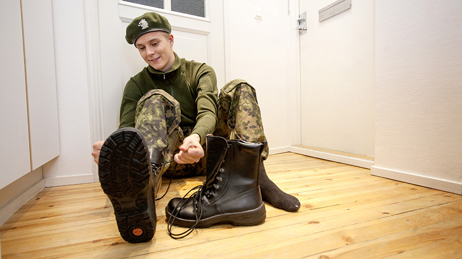 A conscript is tieing shoes.