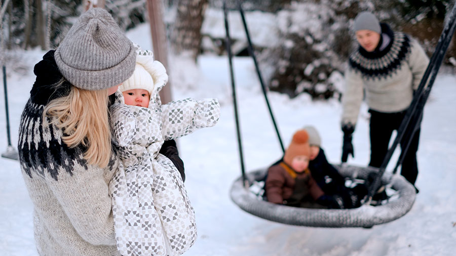 En familj leker i snön.